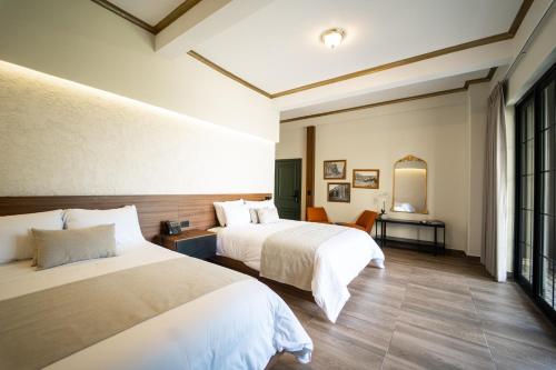 a hotel room with two beds and a mirror at Cardedeu Centro Histórico in San Salvador