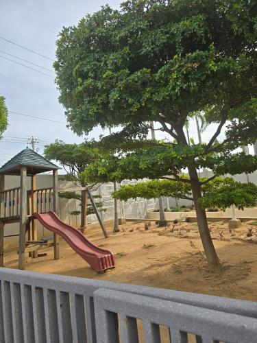 a playground with a red slide next to a tree at Acogedor y Centrico Apto 2hab-1baño in Maracaibo