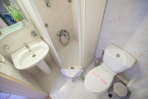 a bathroom with a sink and a toilet and a shower at Nepheli Hotel in Kastrosikia