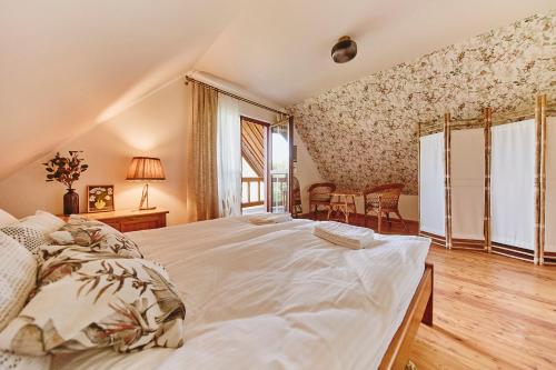 a bedroom with a large bed and a window at Slow House Gaładuś in Radziucie
