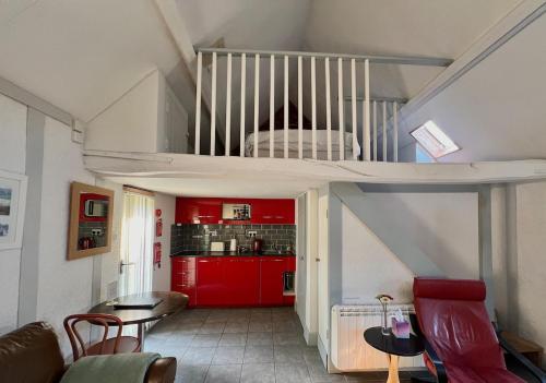 a living room with red cabinets and a kitchen at Barnacle Barn, North Norfolk in Roughton