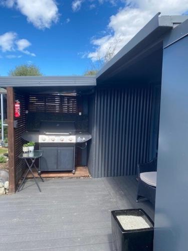 an outdoor kitchen with a grill and a stove at Hallewell Haven in Twizel