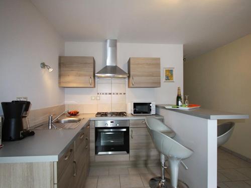 une cuisine avec un évier et une cuisinière four supérieur dans l'établissement Gîte Spacieux entre Épinal et Gérardmer, Terrasse Privative, 5 Pers, Draps Inclus - FR-1-589-273, à Docelles