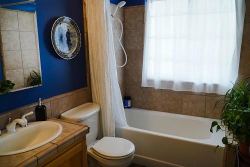 a bathroom with a toilet and a tub and a sink at Wildland Gardens Farm House w Private Hot tub in Joseph