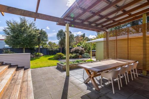 a patio with a wooden table and chairs at Family Retreat in Martinborough 