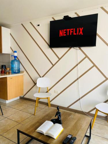 anetflix sign on a wall with a table and chairs at Experiencia Vista Urbana 1Hab-1Baño-1 Estac in Antofagasta