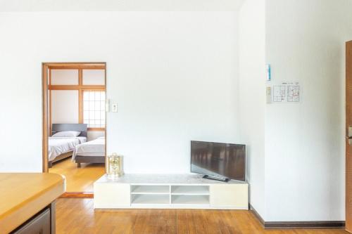 a living room with a tv on a white wall at Raku Raku in Nikko