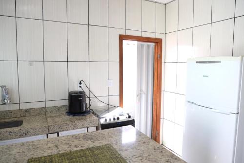 a kitchen with a stove and a white refrigerator at Casa Privativa em Sete Lagoas 35C in Sete Lagoas
