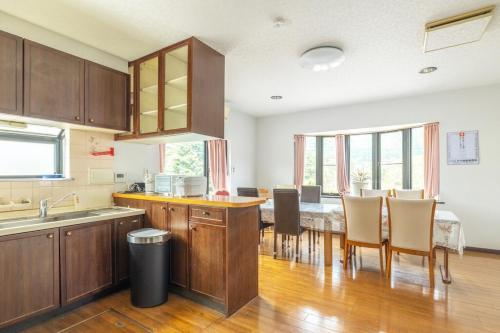 a kitchen with a table and some chairs in a room at Raku Raku in Nikko