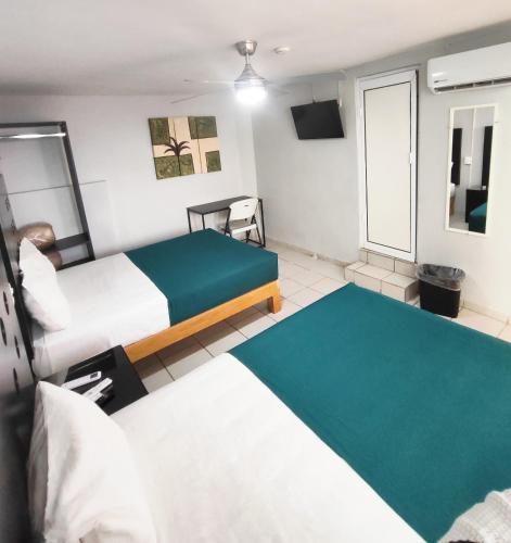 a hotel room with two beds and a tv at Hotel del Refugio in Guadalajara