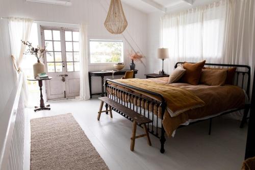 a bedroom with a bed and a bench and a window at The Reads Freycinet - Water Front Property in Coles Bay