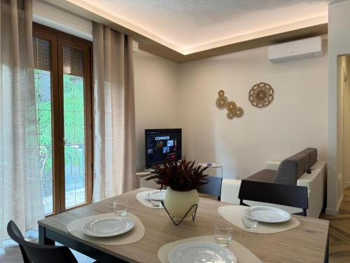a living room with a table and chairs and a television at Luxury Apartment, Appartamento a Passignano sul Trasimeno in Passignano sul Trasimeno