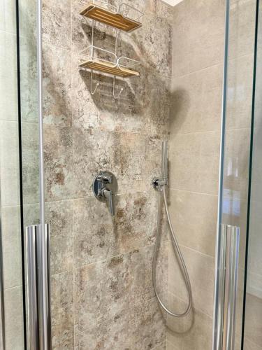a shower with a shower head in a bathroom at Luxury Apartment, Appartamento a Passignano sul Trasimeno in Passignano sul Trasimeno