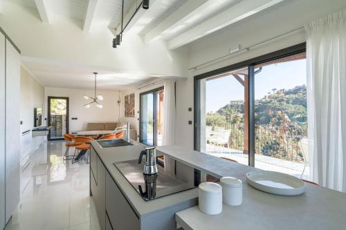 a kitchen with a sink and a large window at Villa Zagara in Savoca
