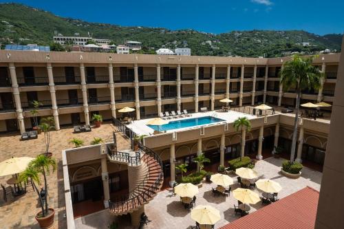 a hotel with a swimming pool and tables and umbrellas at Windward Passage Hotel in Charlotte Amalie