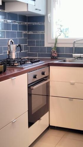 une cuisine avec une cuisinière et un évier dans l'établissement Appartement pour 4 personnes - Accès direct Disneyland & Paris - Proche Gare RER A, à Bussy-Saint-Georges