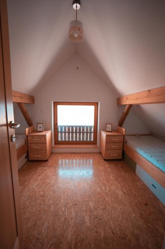 a attic room with two bunk beds and a window at KAJZA KOLOVRAT in Mozirje