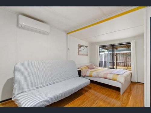 Un dormitorio blanco con una cama y una ventana. en Spacious Home Lakes Entrance, en Lakes Entrance