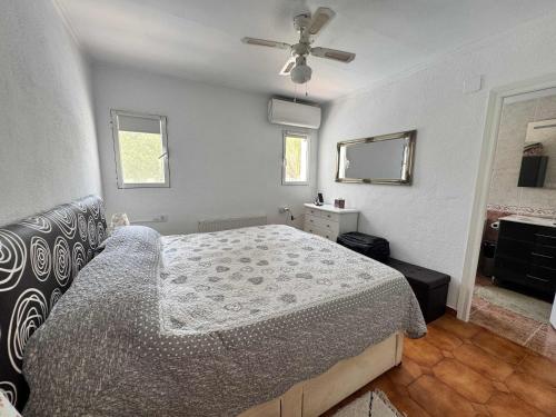 a bedroom with a bed and a ceiling fan at Wonderful villa with private pool summer kitchen in El Tosalet