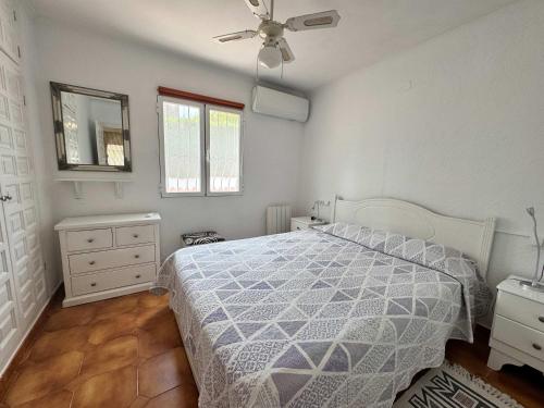 a bedroom with a bed and a ceiling fan at Wonderful villa with private pool summer kitchen in El Tosalet