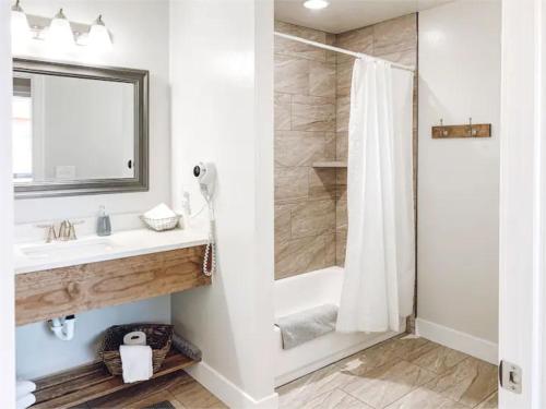 a bathroom with a white sink and a shower at Bybee's Steppingstone Motel in Tropic