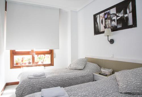 a bedroom with two beds and a window at Alojamiento Miramar in Santoña