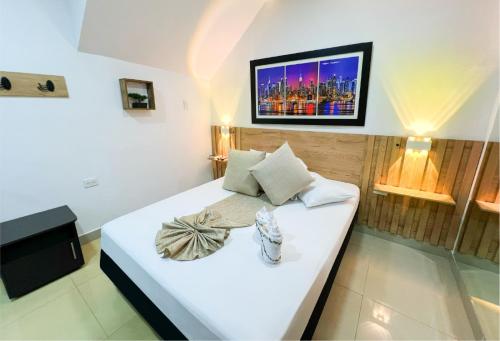 Cama blanca en habitación con TV en la pared en Sixth House Suite, en Cali