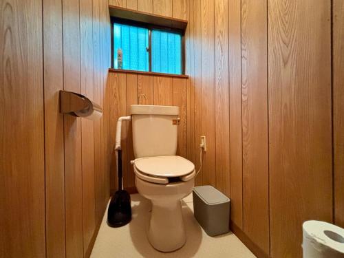 a bathroom with a toilet in a wood paneled bathroom at Mountain villa 北軽井沢 in Tsumagoi
