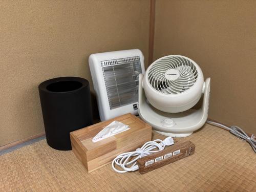 a white fan sitting on the floor next to a box at Mountain villa 北軽井沢 in Tsumagoi