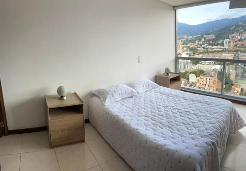 a bedroom with a bed and a large window at Apartamento Loft con vista unica in Itagüí