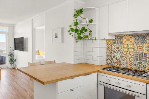 a kitchen with white cabinets and a wooden counter top at Central Fremantle Lifestyle walk to markets, cafe, bars in Fremantle