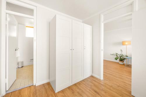 an empty living room with white cabinets and wood floors at Central Fremantle Lifestyle walk to markets, cafe, bars in Fremantle