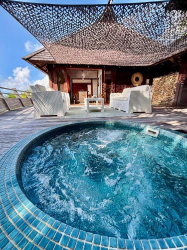 a swimming pool with chairs and a house at Le Fare Tianee, Résidence Légends, BEST VIEW in Moorea