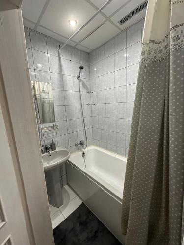 a bathroom with a tub and a sink and a shower at Cozy Apartment- Self Check- In in Riga