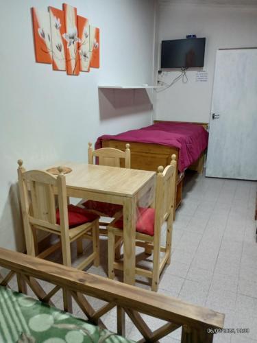 a dining room with a table and a bed at Loft Don Manuel in Trelew