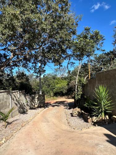 a dirt road with a fence and a tree at Woodhouse Tranquilidade e Conforto no Paraíso, piscina aquecida e ar condicionado in Alto Paraíso de Goiás