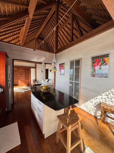 a kitchen with a counter and a table at Villa de Luxe Tianee Le Légends, vue panoramique Ocean ,3 Chambres, 2 Salles de bain, piscine, jacuzzi, salle de sport in Irioa