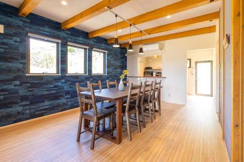 a dining room with a wooden table and chairs at 新築! 一棟貸切 Sea Garden Ishigaki オーシャンビュー in Ishigaki Island