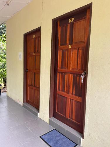 two wooden doors on the side of a building at Lang Buana Eco Park in Jerantut