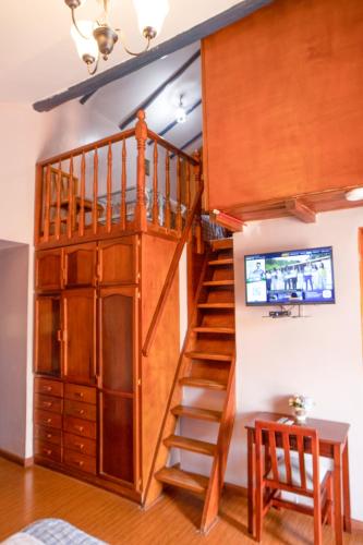 a loft bed with a staircase in a room at Hotel Posada del Angel in Cuenca