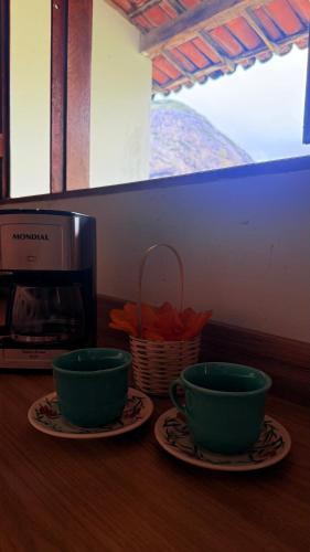 two green cups sitting on plates next to a microwave at Apt Flat 225 Condomínio Pedra do Rodeadouro in Bonito
