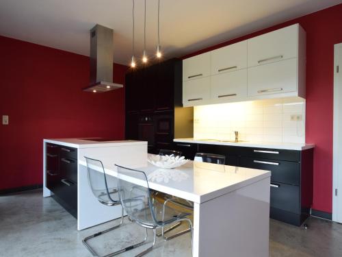 a kitchen with white counters and black cabinets at Modern Cottage in Vaux-sur-Sûre with Sauna in Morhet