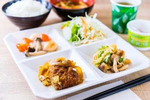 three white plates with food on a table at SUPERHOTEL Matsumoto Oshiroguchi in Matsumoto