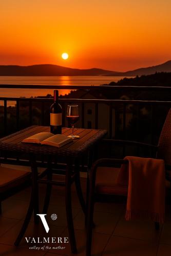 a table with a bottle of wine and a glass at Valmere Members Luxury Sea View Apartment Tivat in Tivat