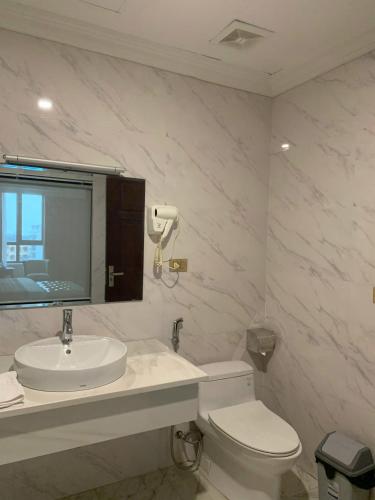 a bathroom with a sink and a toilet and a mirror at Asean Hotel in Hải Dương