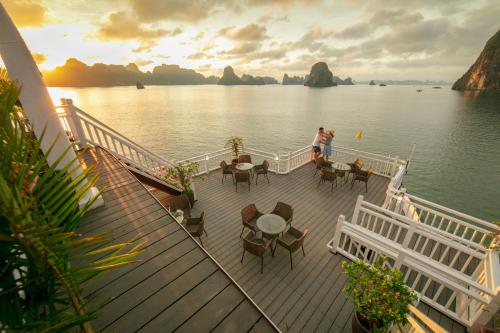 a cruise ship with people on the deck at sunset at Halong Arcadia Cruise in Ha Long