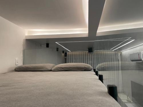 - une chambre avec un lit et une paroi en verre dans l'établissement Studio Zona Sul Laranjeiras RJ, à Rio de Janeiro