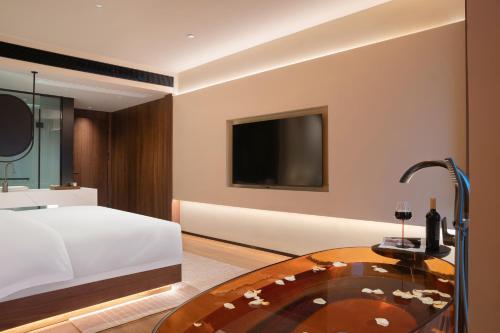 a bedroom with a bed and a glass table at Zhangjiajie Yujie Hotel in Zhangjiajie