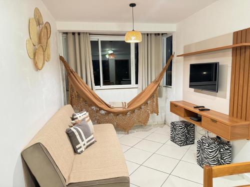 ein Wohnzimmer mit Couch und Hängematte in der Unterkunft Apartamento prainha rua da praia in Arraial do Cabo