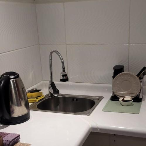 a kitchen counter with a sink and a tea kettle at Apartamento Estocolmo IV in Valdivia